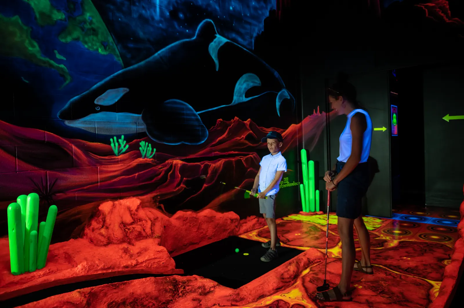 Parent et enfant au mini-golf fluo, à 40 minutes de Victoriaville
